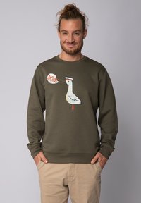 Olijfgroene sweatshirt van katoenmix, met een cartoonvogelontwerp en een oranje spreekwoord 'MOIN'. Geribde manchetten en zoom.