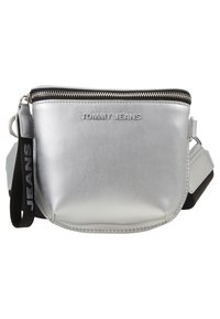Borsa a tracolla sintetica argento con chiusura a zip, logo "TOMMY JEANS" in rilievo e tracolla nera regolabile con il nome del marchio.