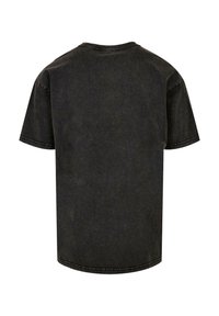 Camiseta de algodón negra de manga corta, con cuello redondo y un corte relajado; presenta una textura ligeramente deslavada y dobladillos cosidos.