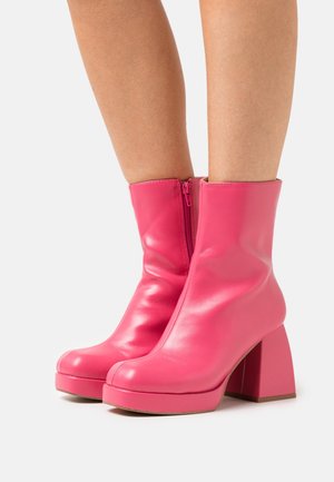 Bottines en cuir rose avec une finition brillante, bout carré et talon carré épais. Comprend une fermeture éclair latérale pour un enfilage facile.