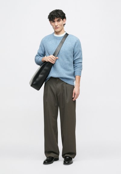 Világoskék gyapjú pulóver, szürke nadrág, fekete bőrcipő és fekete válltáska. Az anyag puha és laza szabású.