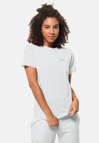 T-shirt gris clair à manches courtes en tissu doux, avec un petit logo en haut à gauche et une coupe décontractée.