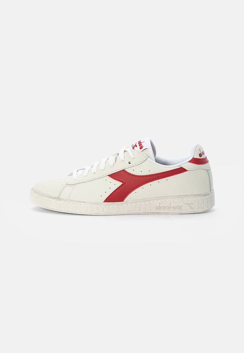 White leather sneaker with a red side stripe, white laces, and textured rubber sole. Features perforations for breathability and a padded collar.