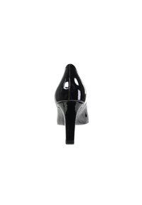 Chaussure à talon haut en cuir verni noir avec un bout pointu et une surface lisse et brillante. Le talon mesure environ 10 centimètres.