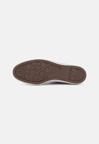 Brown rubber outsole with diamond patterns, white sidewall, textured surface for traction, designed for casual footwear.