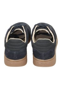 Marineblaue Wildlederschuhe mit einer strukturierten Gummisohle, die ein glattes Rückenteil sowie cremefarbene Futter- und Akzente aufweisen.