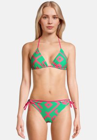 Bikini deux pièces de couleur vert vif avec des motifs géométriques roses. Le haut a des bretelles ajustables autour du cou ; le bas présente des liens sur les côtés et un ourlet contrasté.