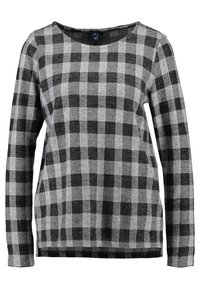 Chemise en maille à carreaux noirs et gris à manches longues, avec un col rond et de petites fentes latérales à l'ourlet.