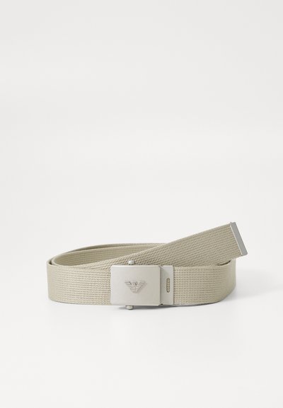 Beige szövött öv, téglalap alakú fémcsattal, logóval, sima fém kiegészítőkkel és texturált szövet felülettel.
