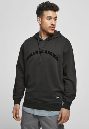 Czarna bluza z kapturem z logo "URBAN CLASSICS" wytłoczonym dużymi literami na klatce piersiowej, z kapturem na sznurki i ściągaczami przy mankietach.