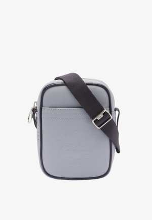 Sac bandoulière gris texturé avec logo embossé, sangle foncée, forme rectangulaire, fermeture zippée et coutures renforcées.