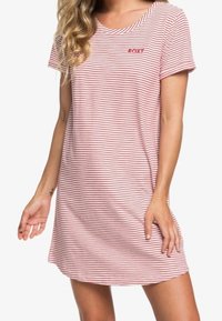 Robe en maille de coton à rayures rouges et blanches, avec un col rond et des manches courtes. Petit logo rouge sur la poitrine.