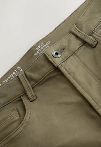 Khaki rovné kalhoty s kovovým knoflíkem, šitými kapsami a látkou označenou jako "komfortní stretch" pro pružnost.