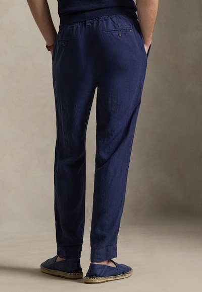 Παντελόνια από λινού ύφασμα σε ναυτικό μπλε χρώμα με χαλαρή εφαρμογή, στενά πόδια, ελαστική μέση και δύο πίσω τσέπες. Συνδυάζονται με ναυτικά εσπαντρίγιες.