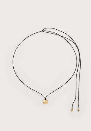 Schwarze Schnur-Halskette mit einem goldfarbigen Anhänger, auf dem "BLACK" eingraviert ist. Das Design umfasst zwei verstellbare Enden mit metallischen Spitzen.