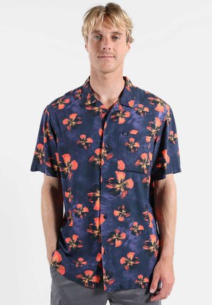 Chemise à manches courtes boutonnée en bleu marine avec un grand motif floral orange et noir, une poche poitrine unique et une coupe décontractée.