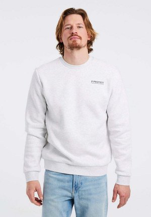 Grijze crewneck sweatshirt van zachte stof, met een klein 'PROTEST' logo op de borst en geribbelde manchetten en zoom. Gekleed met lichtblauwe jeans.