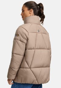 Gevoerde beige jas met een hoge kraag, met ruitvormige stiksels en een subtiel logo op de achterkant. Glad oppervlak en een relaxte pasvorm.