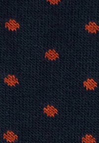 Tessuto blu scuro con piccoli puntini arancioni ricamati, distribuiti uniformemente e caratterizzati da un motivo a zig-zag.