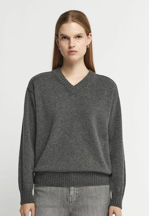 Maglione grigio scuro a collo a V realizzato in morbido materiale a maglia. Presenta polsini e orlo a coste, con una vestibilità comoda. Nessun motivo o accento visibile.