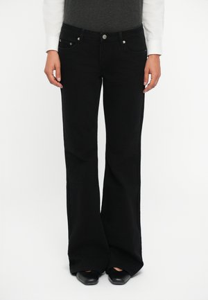 Black flared jeans made of denim, featuring a classic five-pocket design and metal button closure, textured fabric with slight stretch.