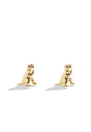 Boucles d’oreilles clous en forme de dinosaure ton or avec petites pierres claires pour les yeux sur fond blanc uni.