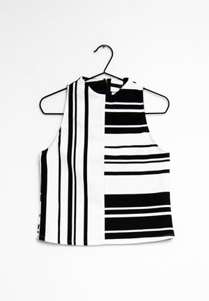Schwarzes und weißes ärmelloses Crop-Top mit hohem Kragen. Es hat eine Mischung aus dicken und dünnen vertikalen Streifen und einen Reißverschluss auf der Rückseite.
