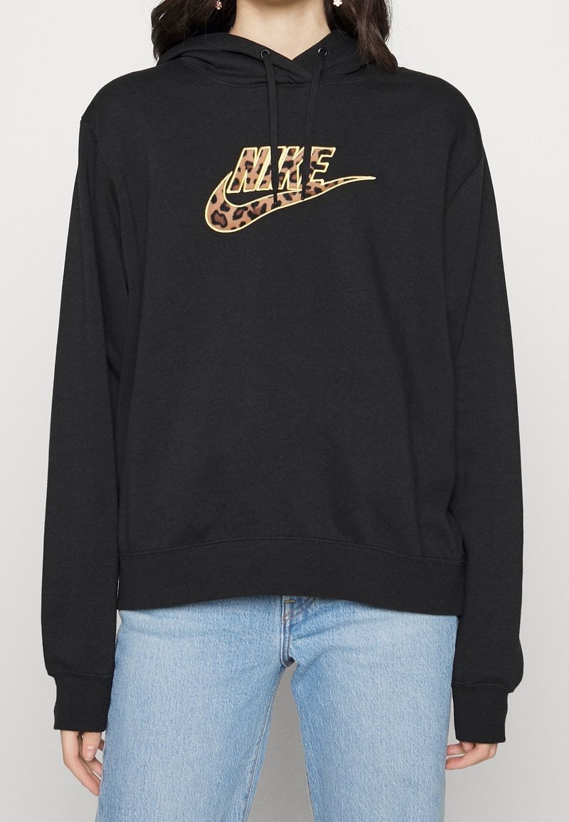 Sudadera con capucha negra con un logo de Nike de estampado de leopardo. Cuenta con mangas largas y un corte relajado. Tejido suave con puños y bajo acanalados.
