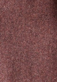 Tissu texturé et tissé dans des nuances de bordeaux et de brun. Présente un motif à carreaux avec une surface douce et duveteuse. Convient pour les vêtements ou le rembourrage.