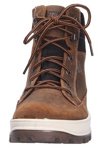 Bottes de randonnée en daim marron avec des accents en tissu noir, dotées de lacets robustes, d'œillets en métal et d'une semelle en caoutchouc blanc avec une surface texturée.