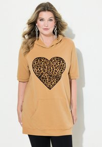 Haut à capuche moutarde à manches courtes, présentant un motif de cœur imprimé léopard noir et une poche avant. Tissu doux avec une coupe décontractée.