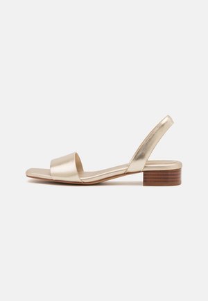 Gold metallic sandal with a square toe, wide front strap, and a slingback design. Features a low, sturdy wooden block heel. Smooth texture.