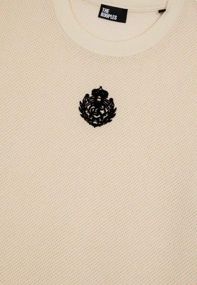 Crème, gestructureerde gebreide trui met een ronde halslijn, voorzien van een zwart geborduurd embleem op de borst en het label "THE KOOPLES" aan de hals.