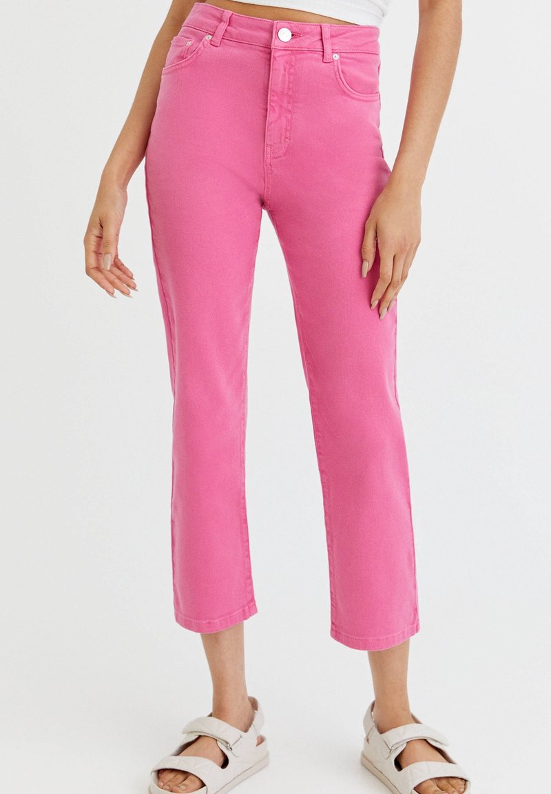 Pantalon court en denim rose à taille haute, avec poches avant, braguette zippée et coupe droite. Tissu texturé.