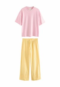 T-shirt rose à manches courtes sur un pantalon large à rayures jaunes avec taille élastique et cordon de serrage. Tissu doux, design décontracté.