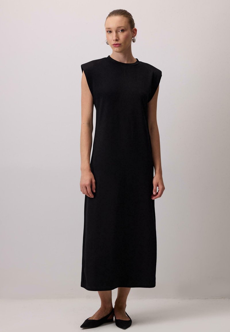 Must esinev must sleeveless midi kleit, millel on ümar kaelus, valitud pehmest kangast. Kleit sisaldab kergeid õlavarrepolste, ning on sirge lõikega.