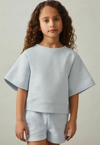 Helles blaues T-Shirt mit kurzen Ärmeln und passenden Shorts aus weichem Stoff, mit lockerer Passform und glatter Textur.
