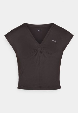 Haut de sport noir avec un décolleté en V et de courtes manches ballon. Fabriqué en tissu lisse avec un détail central en torsion. Présente un petit logo Puma.