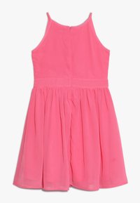 Felle roze mouwloze jurk met zip aan de achterkant, aansluitende bodice en geplooide rok, tentoongesteld tegen een witte achtergrond.