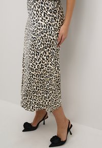 Leopardenmuster Midi-Rock aus leichtem Material mit fließendem Design. Schwarze Absätze mit einer Rosenakzent an der Spitze und einer spitz zulaufenden Silhouette.