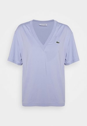 Light purple short-sleeve V-neck Lacoste T-shirt featuring a small green crocodile logo on the left chest.