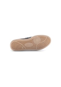 Semelle en caoutchouc avec un motif en chevrons texturé, comportant un logo central et une couleur beige clair avec des accents beige.