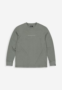 Langsleeve vervaagde groene crewneck sweatshirt met geribbelde manchetten en de tekst "BUTCHER OF BLUE" gedrukt op de voorkant in het midden.