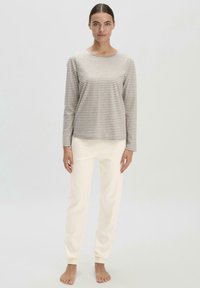Striped long-sleeve top in beige and cream; paired with cream, tapered jogger pants; soft fabric; relaxed fit; minimal design.