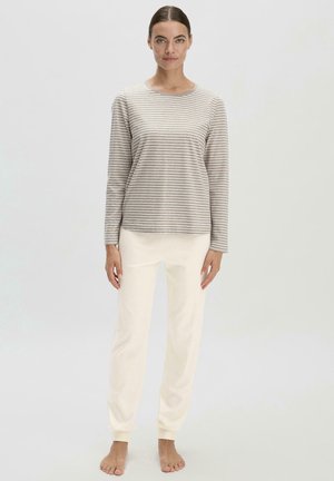 Gestreiftes Langarmoberteil in Beige und Creme; kombiniert mit cremefarbenen, taillierten Jogginghosen; weicher Stoff; lockere Passform; minimalistisches Design.