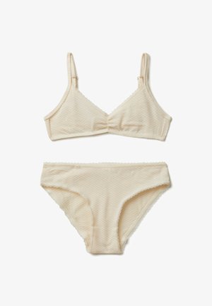 Completo di lingerie beige che presenta un bralette testurizzato con spalline regolabili e un bikini abbinato, entrambi con bordi ondulati.