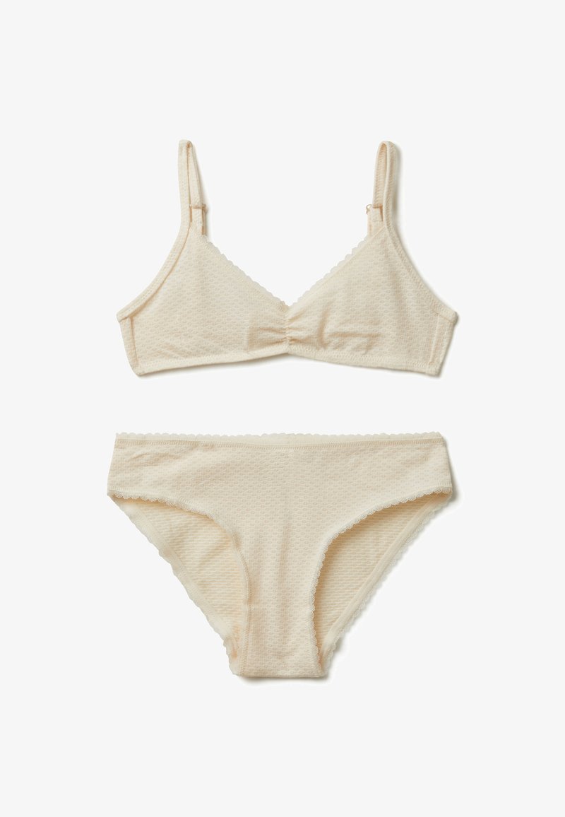 Beige sada spodního prádla s texturovaným braletem a nastavitelnými ramínky a odpovídajícími kalhotkami ve stylu bikiny, obě s vlnitými okraji.