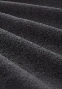 Mörkgrått tyg med en mjuk, strukturerad yta, med släta veck och en subtil lyster som indikerar ett mysigt material.