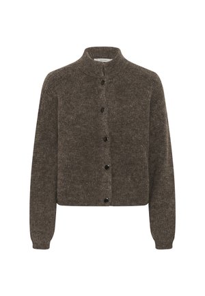 Jeune femme portant un pull marron boutonné, un jean gris large avec ourlets, une ceinture chaîne argentée et des chaussures noires à talons.