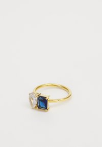Anello d'oro con due pietre preziose: una pietra trasparente a forma di pera e una pietra quadrata blu scuro, incastonate in una bande elegante dal design minimale.